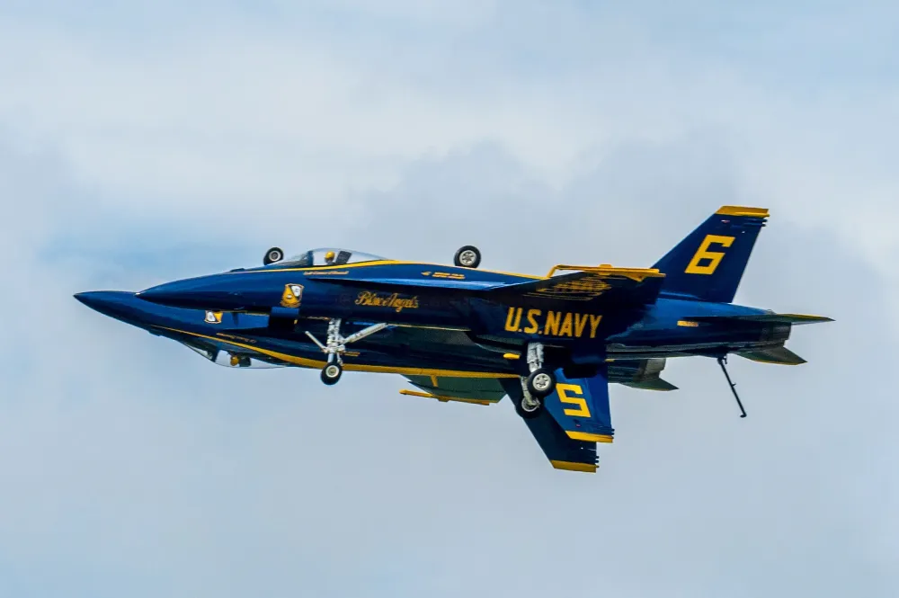 Blue Angels jet no. 6 flying inverted with landing gear down, close above no. 5, against a cloudy sky at the Duluth airshow.